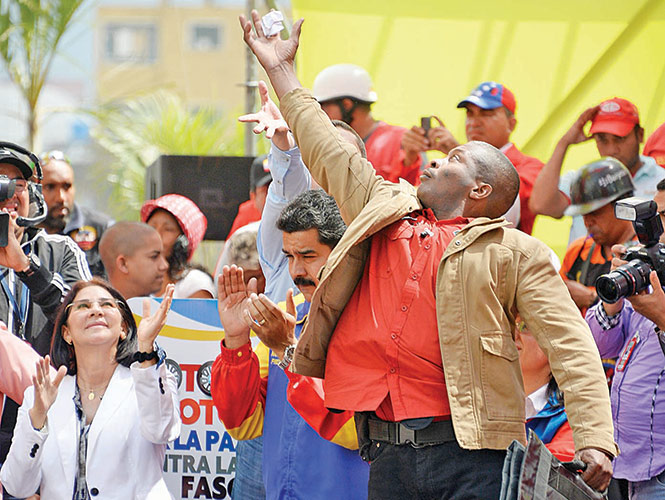 Un guardaespaldas salta para alcanzar una bola de papel lanzada al presidente Nicolás Maduro en un mitin en el Palacio de Miraflores.