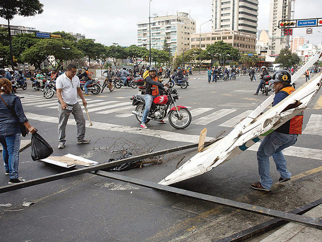 Motociclistas liberan una carretera de Caracas que fue bloqueada por horas por manifestantes que se oponen al gobierno de Nicolás Maduro.