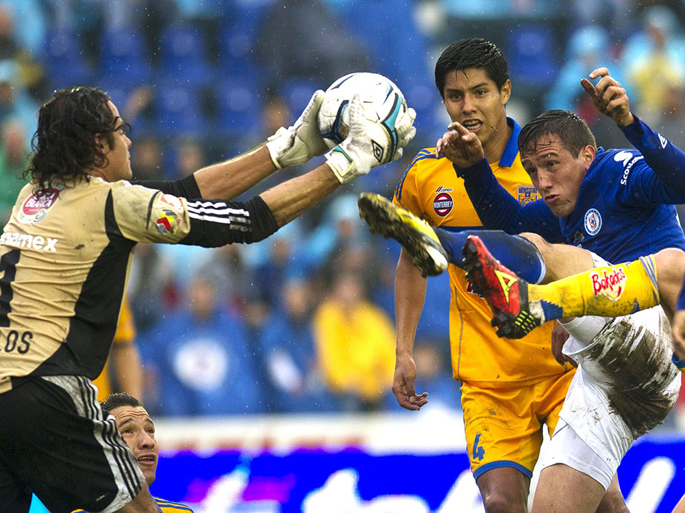 Jerónimo Amione trata de peinar el balón ante la salida de Enrique Palos. Cruz Azul 0 – 1 Tigres (EFE)