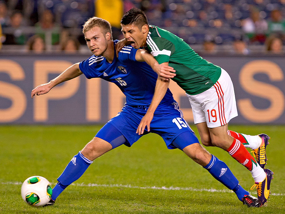 Oribe Peralta sufre una dura entrada de Jani Tanska (Mexsport)