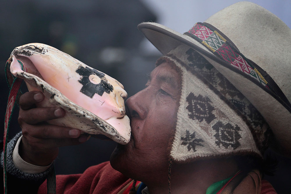 Un chamán boliviano sopla un caracol durante el lanzamiento del satélite espacial Tupac Katari, en La Paz. Un chamán boliviano sopla un caracol durante el lanzamiento del satélite espacial Tupac Katari, en La Paz.
