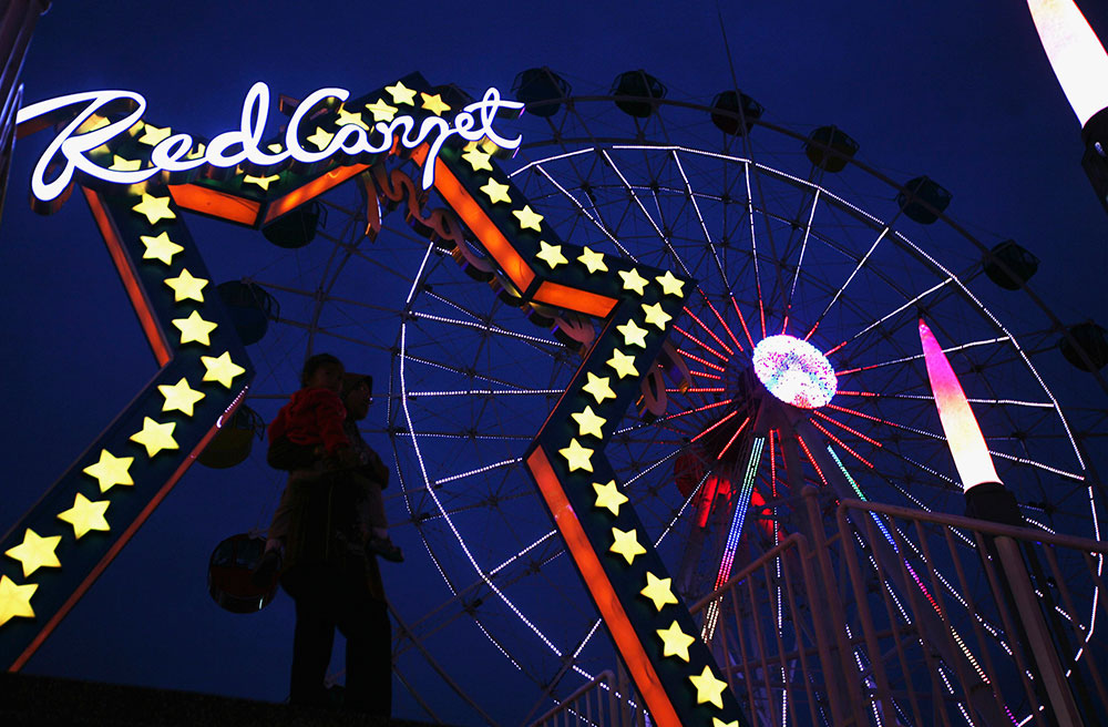 La sombra de una mujer cargando a su hijo se ve frente a la marquesina centro de atracciones Kuala Lumpur. La sombra de una mujer cargando a su hijo se ve frente a la marquesina centro de atracciones Kuala Lumpur.