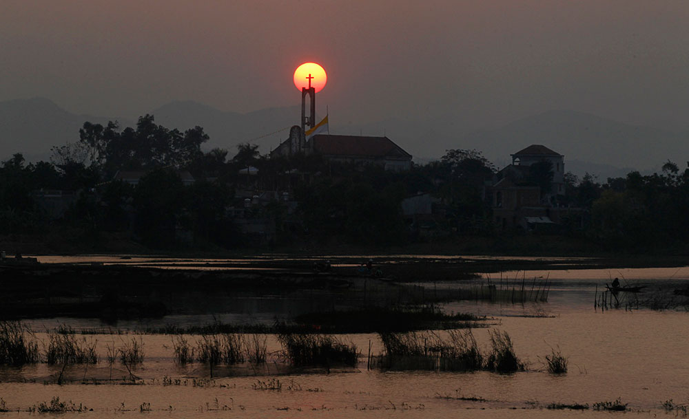 Una hermosa postal de una puesta de Sol cerca de una iglesia de Vietnam. Una hermosa postal de una puesta de Sol cerca de una iglesia de Vietnam.