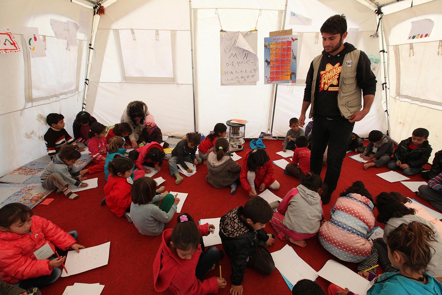 Educación pese a todo. Varios niños toman clases en un campo de refugiados a las afueras de Arbil, Irak.