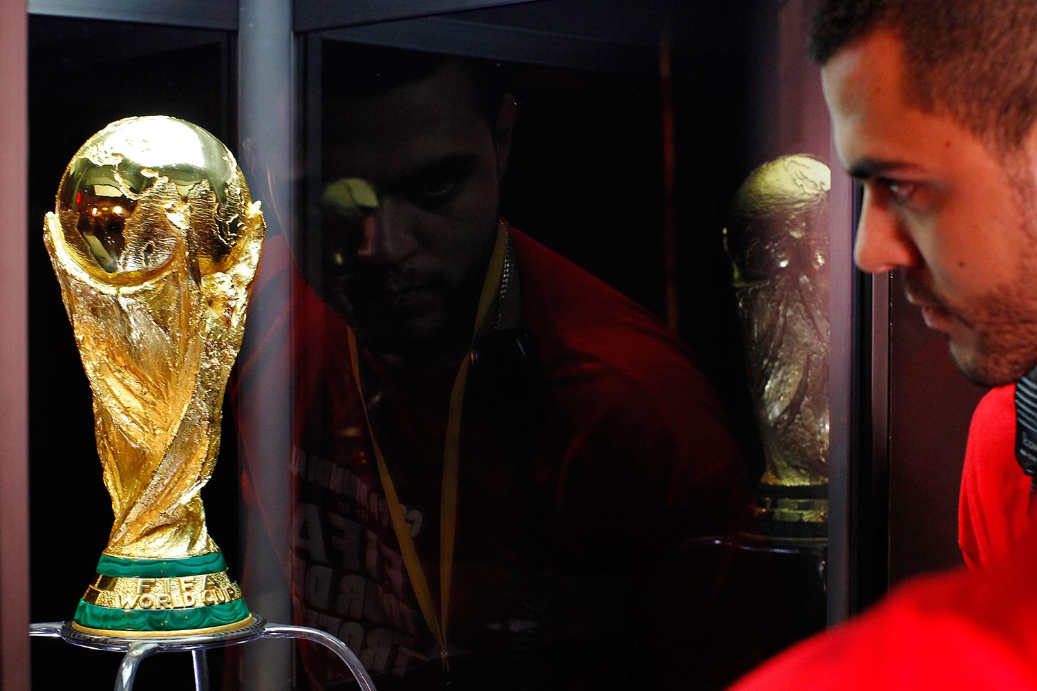 Futbol. Un hombre se asombra con el trofeo de la Copa Mundial de Futbol de FIFA.