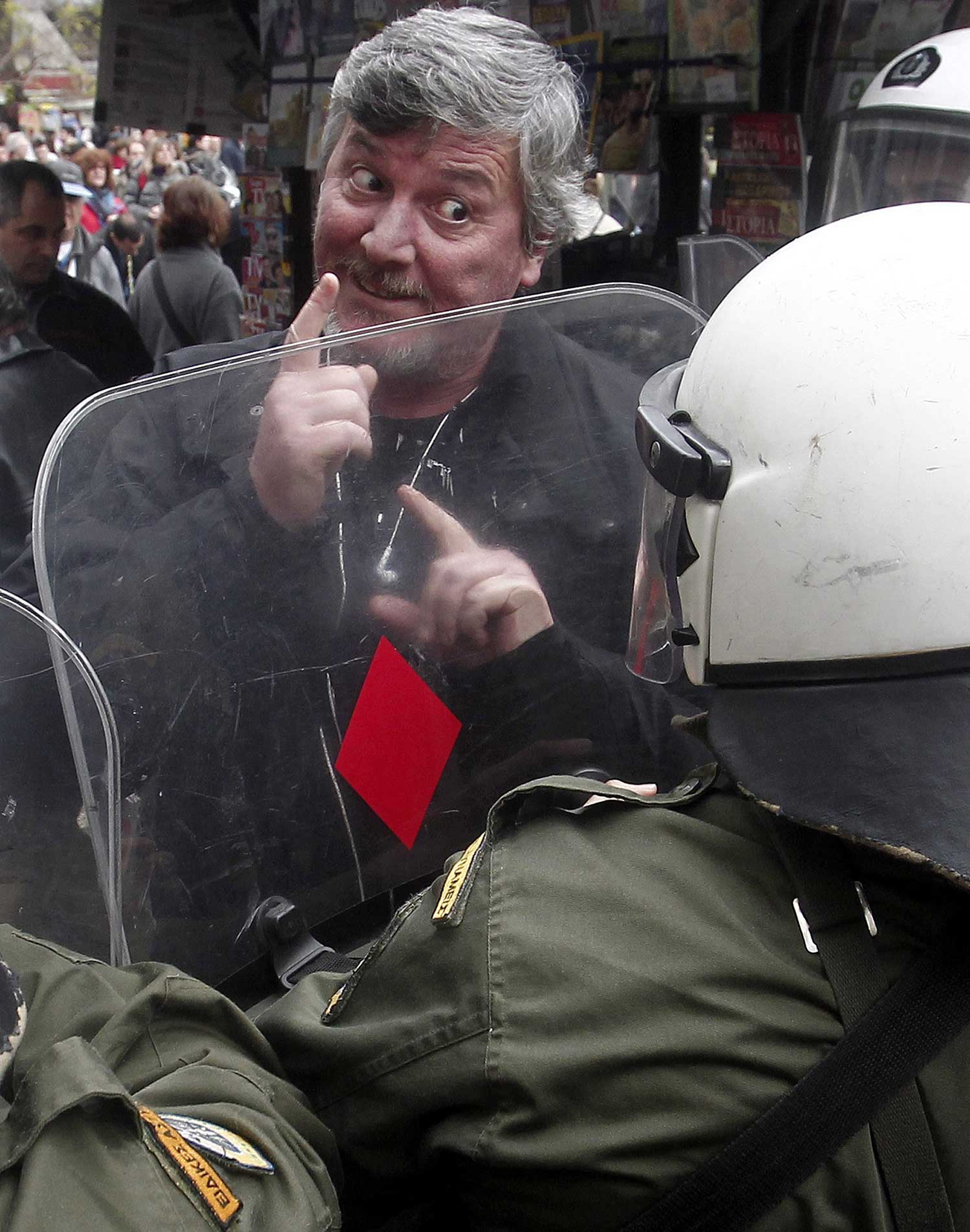 Un manifestante habla con un policía de Grecia durante una manifestación.
