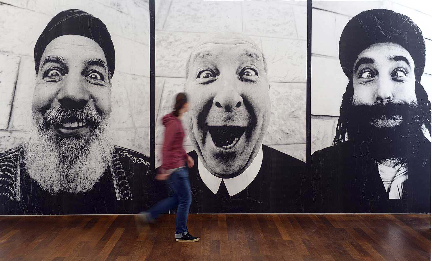 Un visitante observa una serie de fotografías del artista francés conocido como JR.