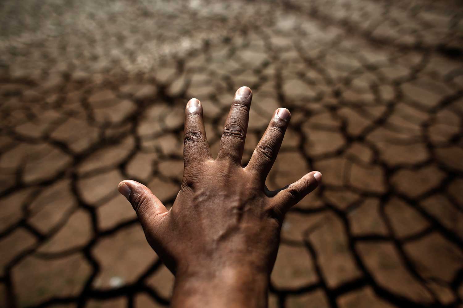La mano de un hombre crea una sombra que se refleja en el piso seco de Sao Paulo.