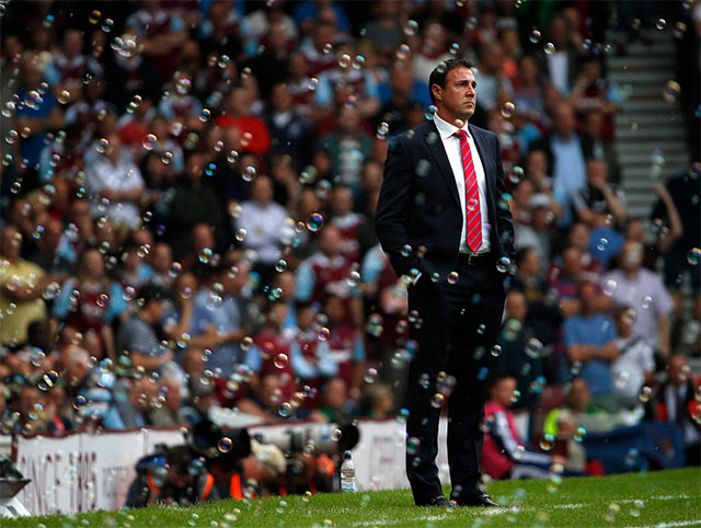 Odisea burbujas. Malky Mackay, técnico del equipo inglés de futbol Cardiff City, es rodeado por cientos de burbujas luego de que su equipo recibiera un gol en contra, en Londres.