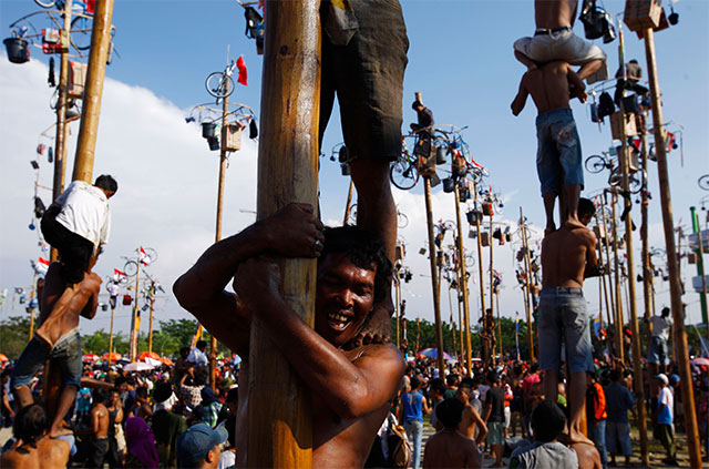 Fiesta nacional. Decenas de indonesios participan en un concurso de 'palo encebado' con motivo de las celebraciones por el 68 aniversario de la independencia del país.