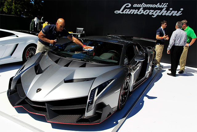 No es el Batimóvil. Un hombre limpia el parabrisas de un Lamborghini Veneno que está en exhibición en un evento de automóviles en California.