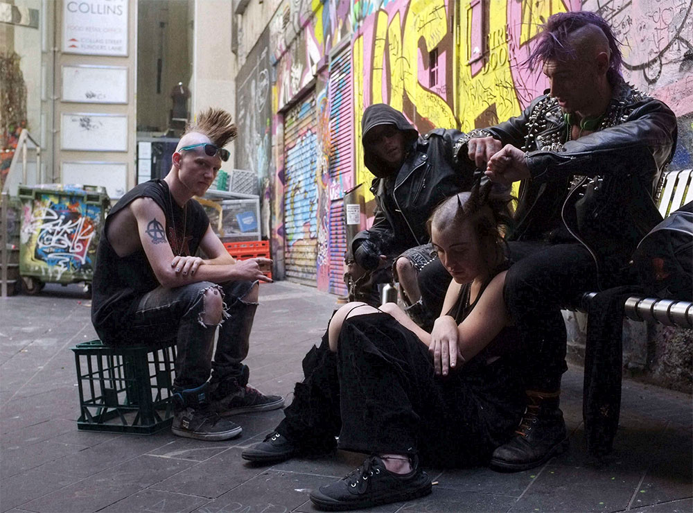 Tratamiento de belleza. Un joven punk le arregla el peinado a una colega en un parque de la ciudad de Melbourne, en Australia.