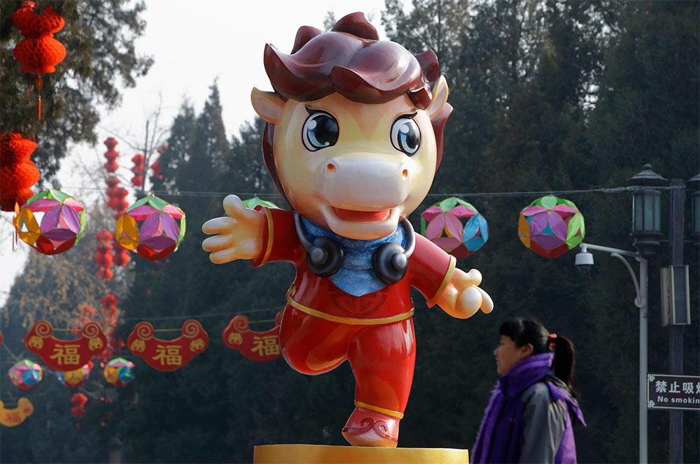 Un año que relincha. Una mujer pasa frente a la escultura de un caballo dispuesta especialmente para los festejos del Año Nuevo Lunar, en la ciudad de Pekín, en China; los festejos ocurrirán el 31 de enero.