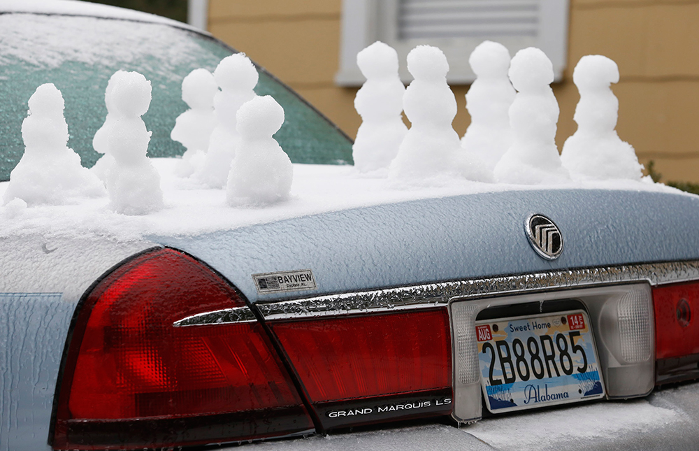 Piden 'aventón'. Pequeños muñecos de nieve adornan la cajuela de un automóvil en la localidad de Mobile, Alabama, azotada por una inusual tormenta de invierno que ha paralizado a varias ciudades de la región.
