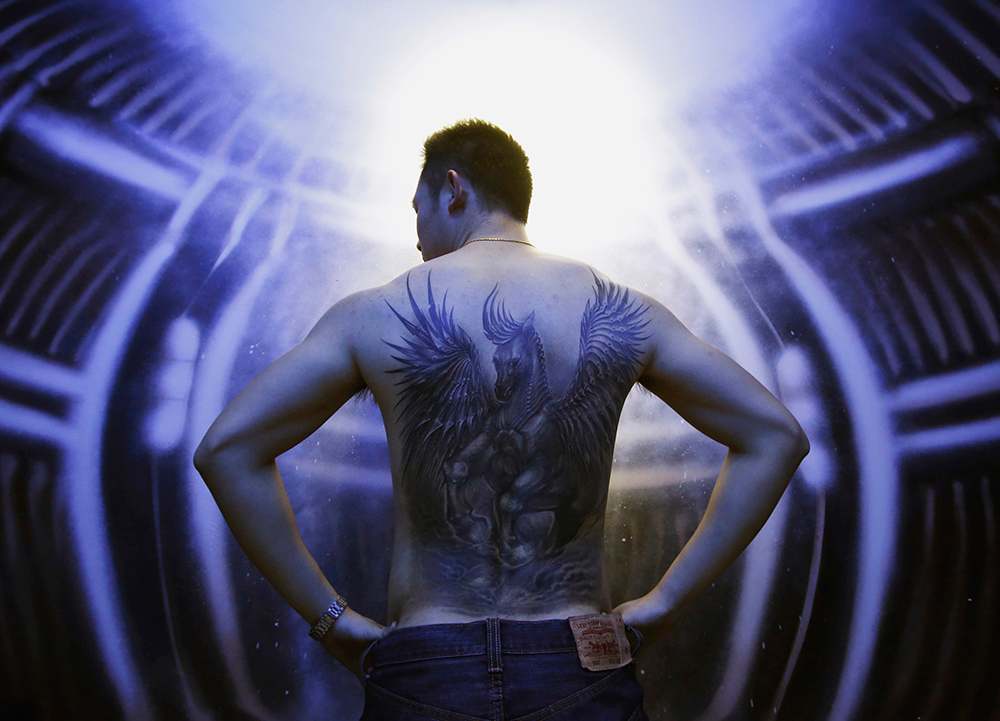 'Vaquero' al desnudo. Un hombre presume su tatuaje recién terminado por la artista Sun Lan, en la ciudad de Pekín, en China.