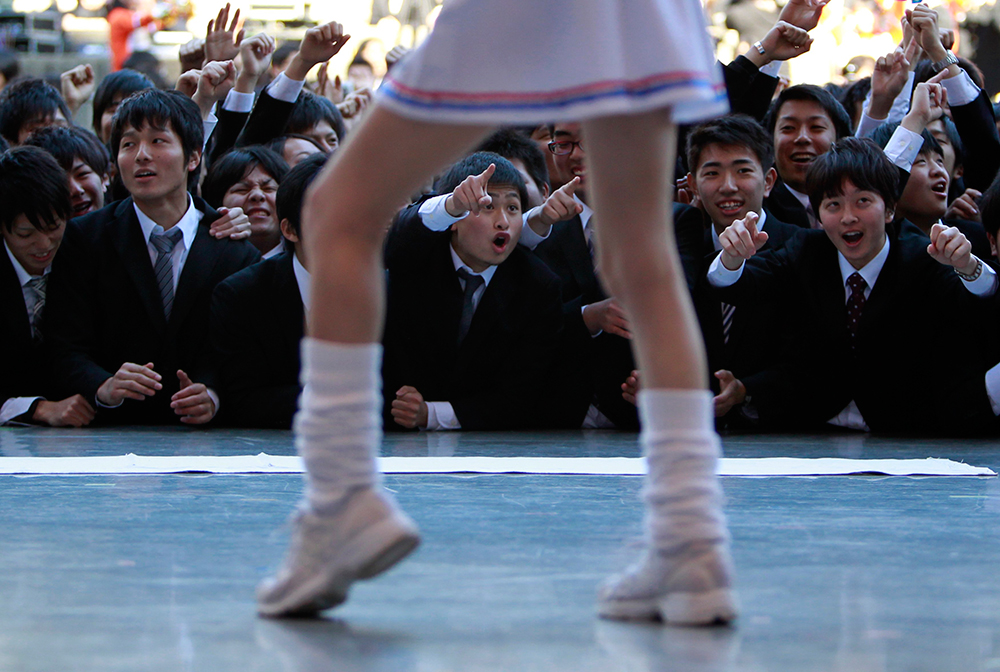Qué piernas. Estudiantes japoneses gritan eufóricos ante un espectáculo de porristas en la ciudad de Tokio.