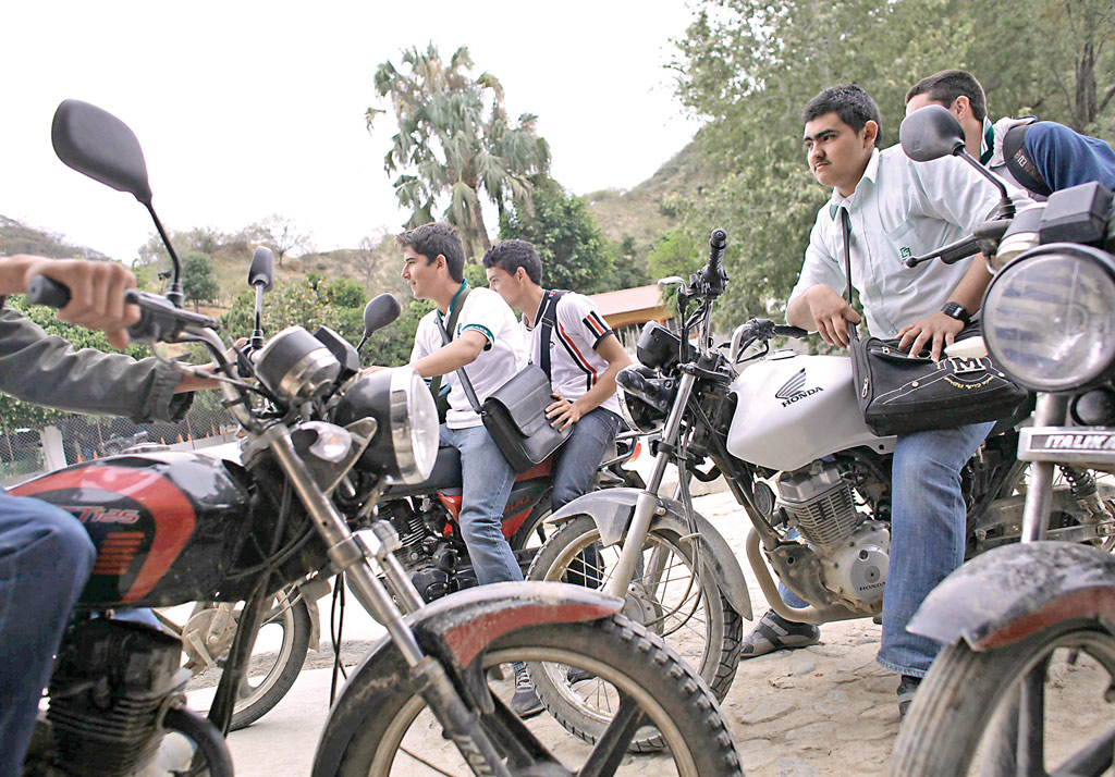 Jóvenes motociclistas toman un descanso frente a una tienda en el poblado de La Tuna, Badiraguato, donde nació y vivió su niñez Joaquín Guzmán Loera. Jóvenes motociclistas toman un descanso frente a una tienda en el poblado de La Tuna, Badiraguato, donde nació y vivió su niñez Joaquín Guzmán Loera.